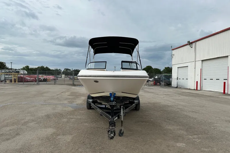 Slide: The Image of 2023 Bayliner VR4 Bowrider OB on trailer, parked outdoors near a warehouse. - 3