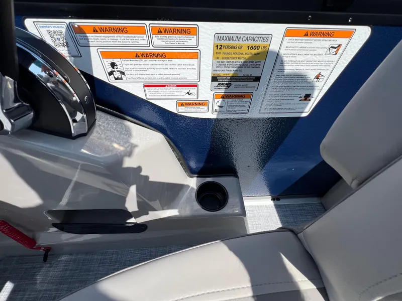 Slide: The Image of 2025 Premier 220 Sunscape boat interior with warning labels and seating area. - 8