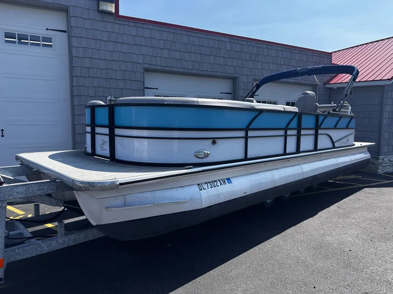 Slide: The Image of 2020 Misty Harbor 2585 Biscayne Bay CE pontoon boat on trailer, parked outside. - 0