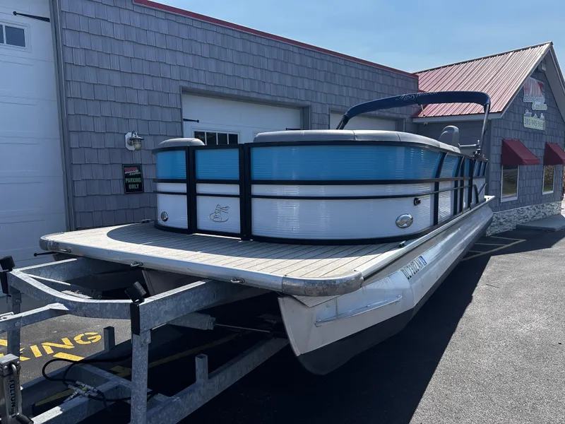 Slide: The Image of 2020 Misty Harbor 2585 Biscayne Bay CE pontoon boat on trailer, parked outside building. - 2