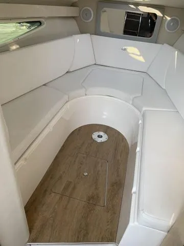 Slide: The Image of 2025 Regal 28 Express cabin interior with white seating and wood flooring. - 17