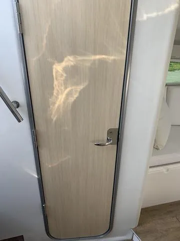 Slide: The Image of 2025 Regal 28 Express cabin door with sleek wood finish. - 18