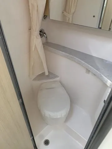 Slide: The Image of 2025 Regal 28 Express boat bathroom with compact toilet and sink. - 19