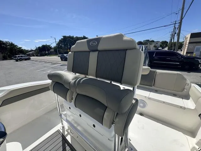 Slide: The Image of 2025 Key West 219 FS boat interior with cushioned seating in a parking lot. - 7