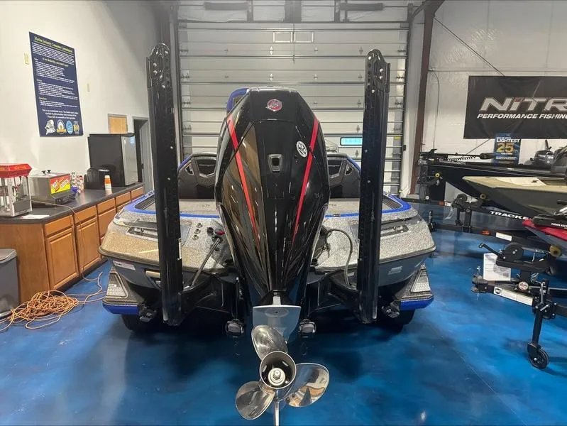 Slide: The Image of 2024 Ranger Z 521 R CUP ED boat in a garage, rear view with motor and propeller. - 2