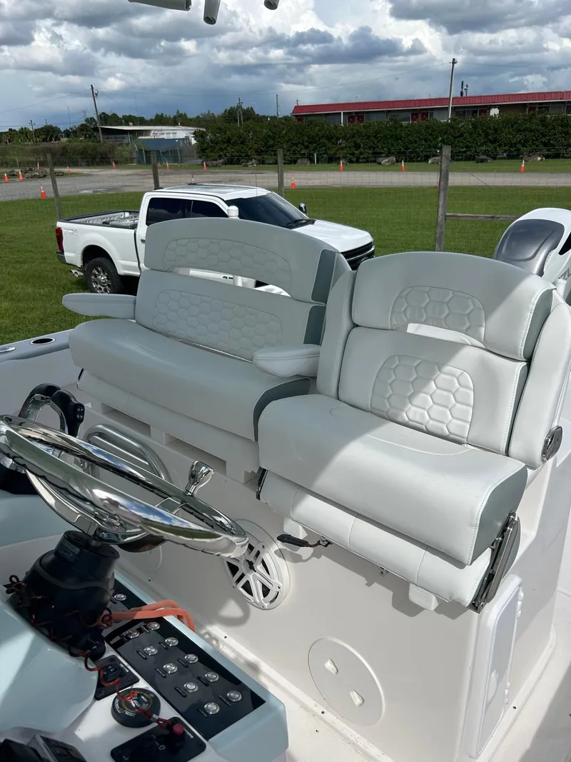 Slide: The Image of 2022 Stamas 33T Aventura boat seats with white upholstery and steering wheel. - 8