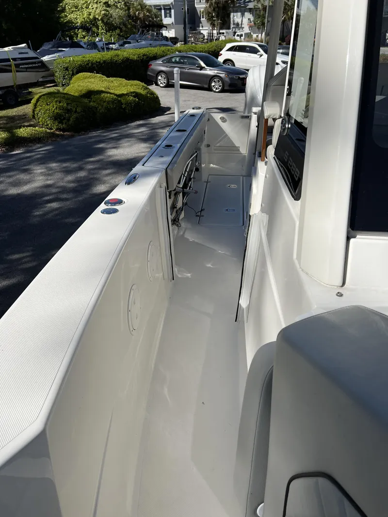 Slide: The Image of 2023 Pursuit S 288 boat deck, sleek design, parked outdoors. - 14