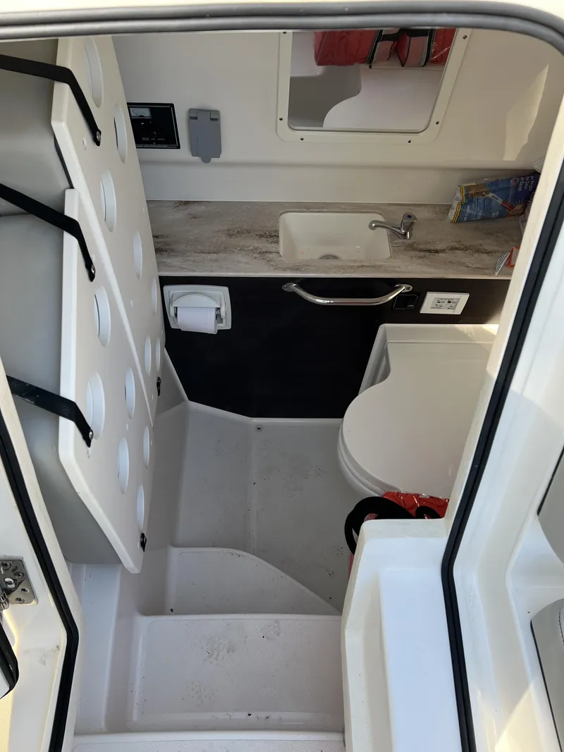 Slide: The Image of 2023 Pursuit S 288 boat interior with compact bathroom and sink. - 15