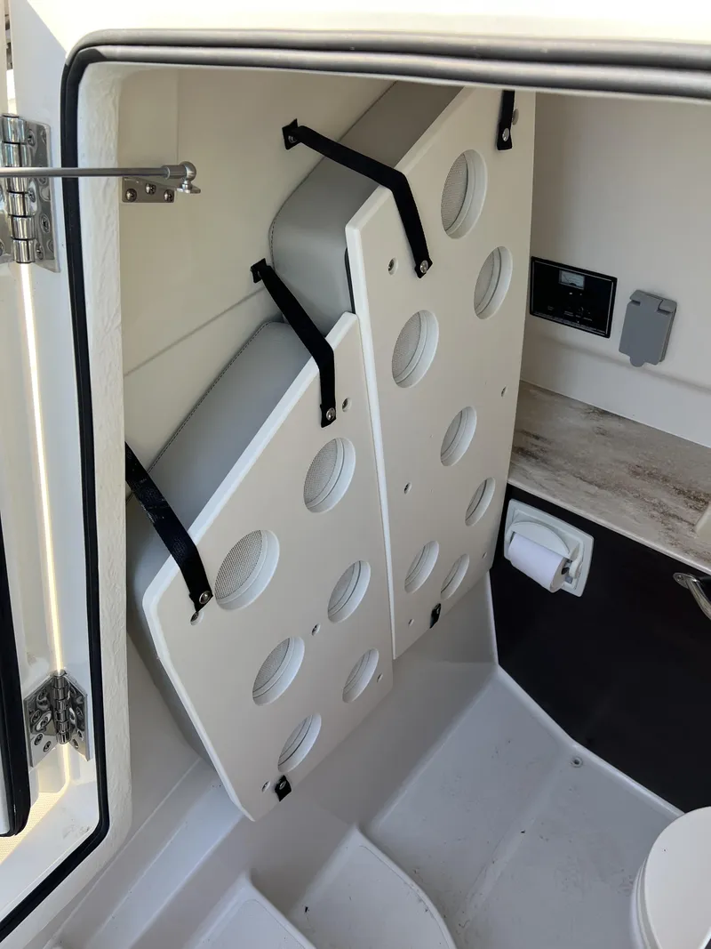 Slide: The Image of 2023 Pursuit S 288 boat interior storage compartment with secure padding and modern design. - 16