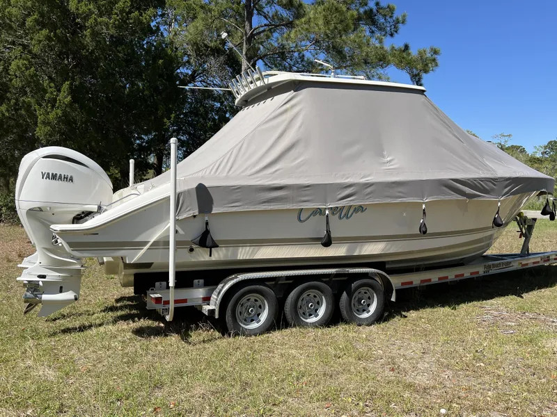 Slide: The Image of 2023 Pursuit S 288 boat with cover on trailer, featuring Yamaha engines. - 2