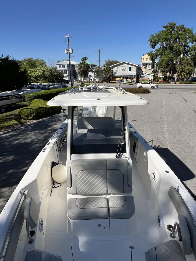 Slide: The Image of 2023 Pursuit S 288 boat with seating, parked in a sunny urban area. - 21