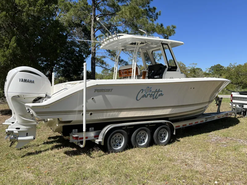 Slide: The Image of 2023 Pursuit S 288 boat on trailer with Yamaha engines, parked outdoors. - 26