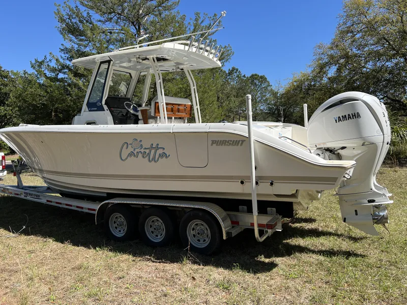 Slide: The Image of 2023 Pursuit S 288 boat on trailer with Yamaha engine in grassy area. - 3