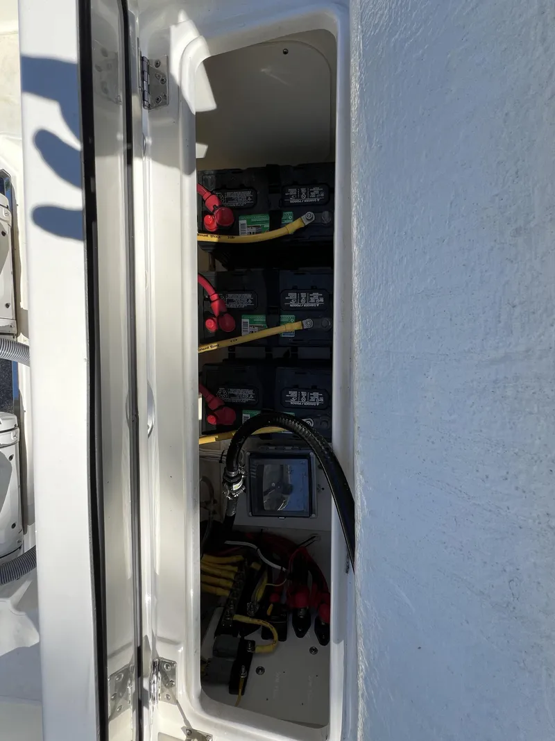 Slide: The Image of 2023 Pursuit S 288 boat battery compartment with cables and connections. - 32