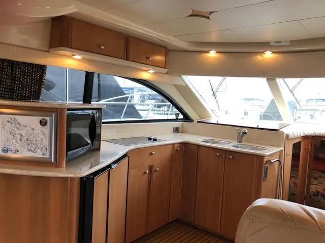 Slide: The Image of Luxurious 2003 Meridian 411 yacht interior with modern kitchen and elegant wood cabinetry. - 11