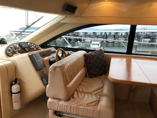 Slide: The Image of Interior of 2003 Meridian 411 yacht with beige seating and wooden table, overlooking marina. - 18