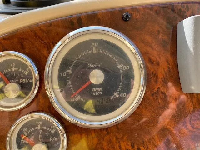 Slide: The Image of Dashboard gauges of a 2003 Meridian 411 boat, featuring RPM and PSI indicators. - 23