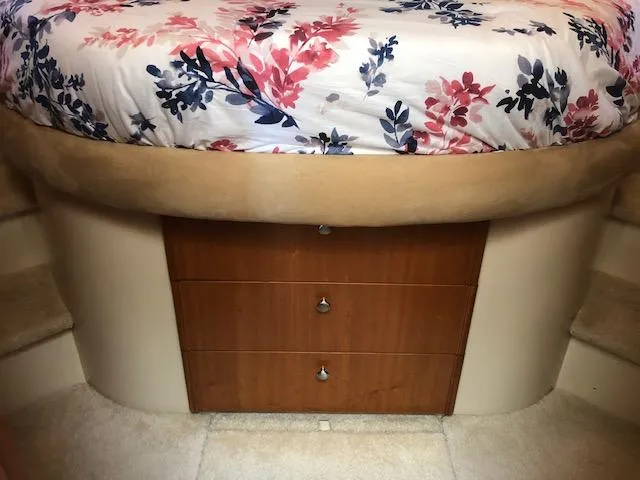 Slide: The Image of Bed with floral bedding and wooden drawers in a 2003 Meridian 411 yacht interior. - 33