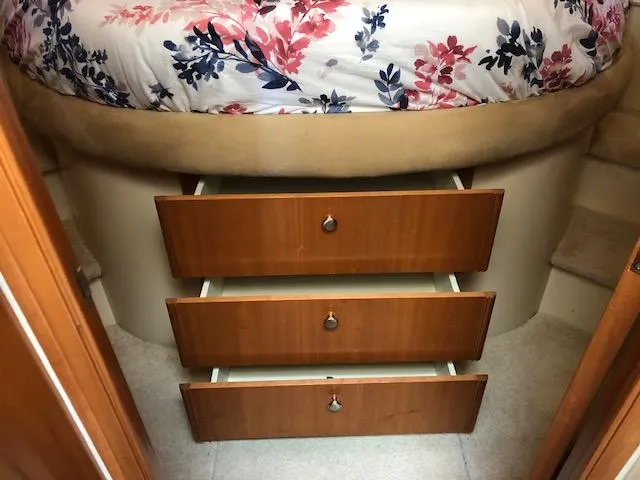 Slide: The Image of Three wooden drawers under a floral bed in a 2003 Meridian 411 yacht. - 34