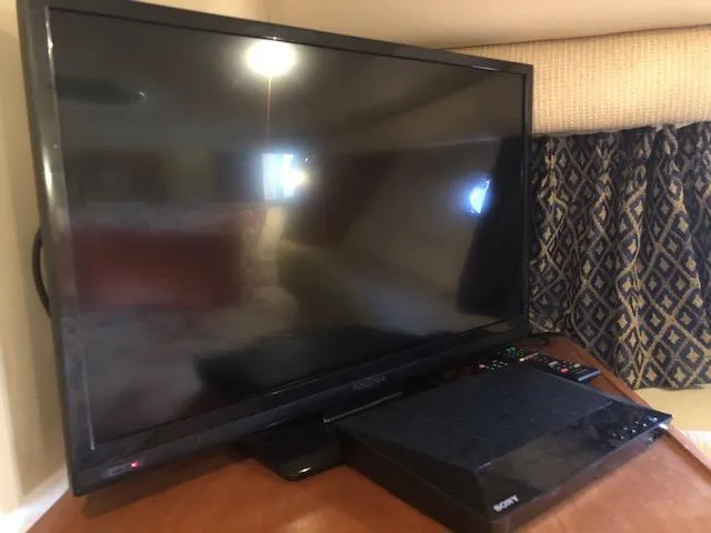 Slide: The Image of Flat-screen TV and electronic device on wooden surface in a cozy room setting. - 38