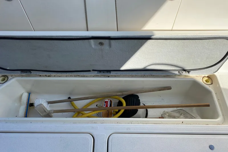 Slide: The Image of Storage compartment on a 2003 Meridian 411 boat with cleaning tools and hose. - 4