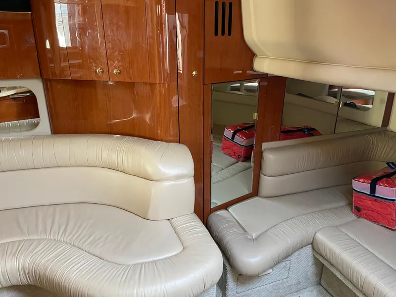 Slide: The Image of Interior of 2001 Sea Ray 380 Sundancer with beige leather seating and wooden cabinetry. - 15