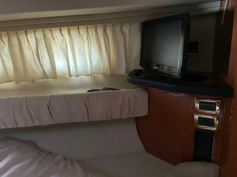Slide: The Image of 2001 Sea Ray 380 Sundancer cabin interior with TV and curtains. - 19