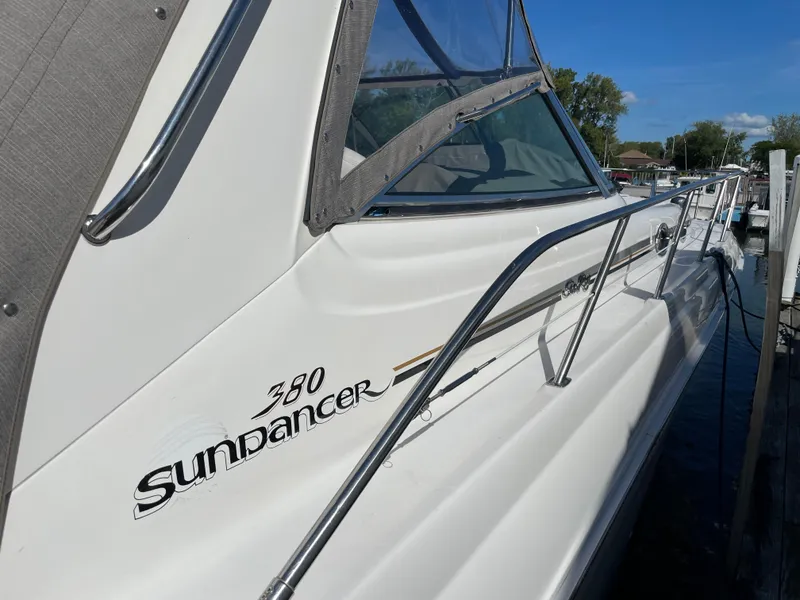Slide: The Image of 2001 Sea Ray 380 Sundancer yacht docked, side view with railing and logo. - 3