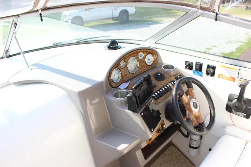 Slide: The Image of 2006 Rinker 270 Express Cruiser helm with wood accents and modern controls. - 21
