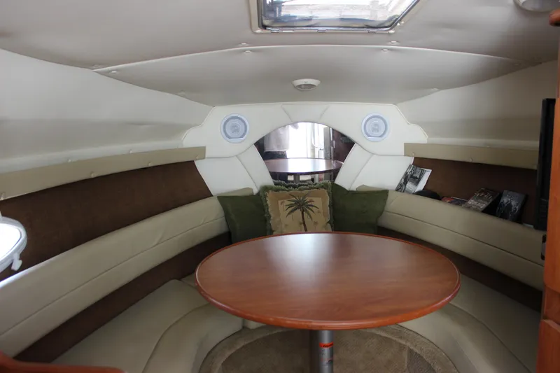 Slide: The Image of Interior of 2006 Rinker 270 Express Cruiser with round table and cushioned seating. - 29