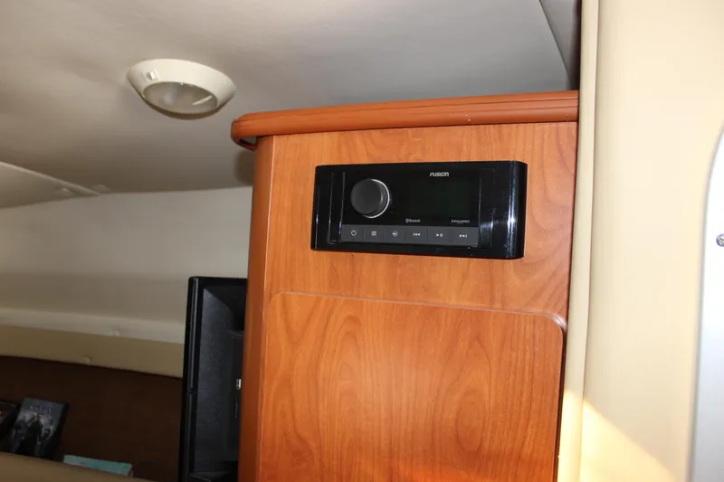 Slide: The Image of Interior of 2006 Rinker 270 Express Cruiser with wood paneling and audio system. - 32