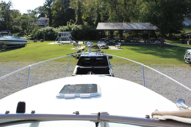 Slide: The Image of 2006 Rinker 270 Express Cruiser on trailer, parked near a pavilion and grassy area. - 48