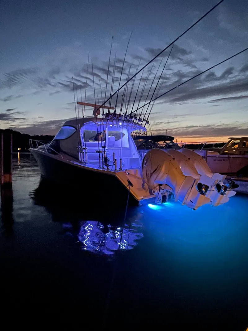 Slide: The Image of Jupiter 41 SB 2021 boat with illuminated stern at sunset, docked in marina. - 17