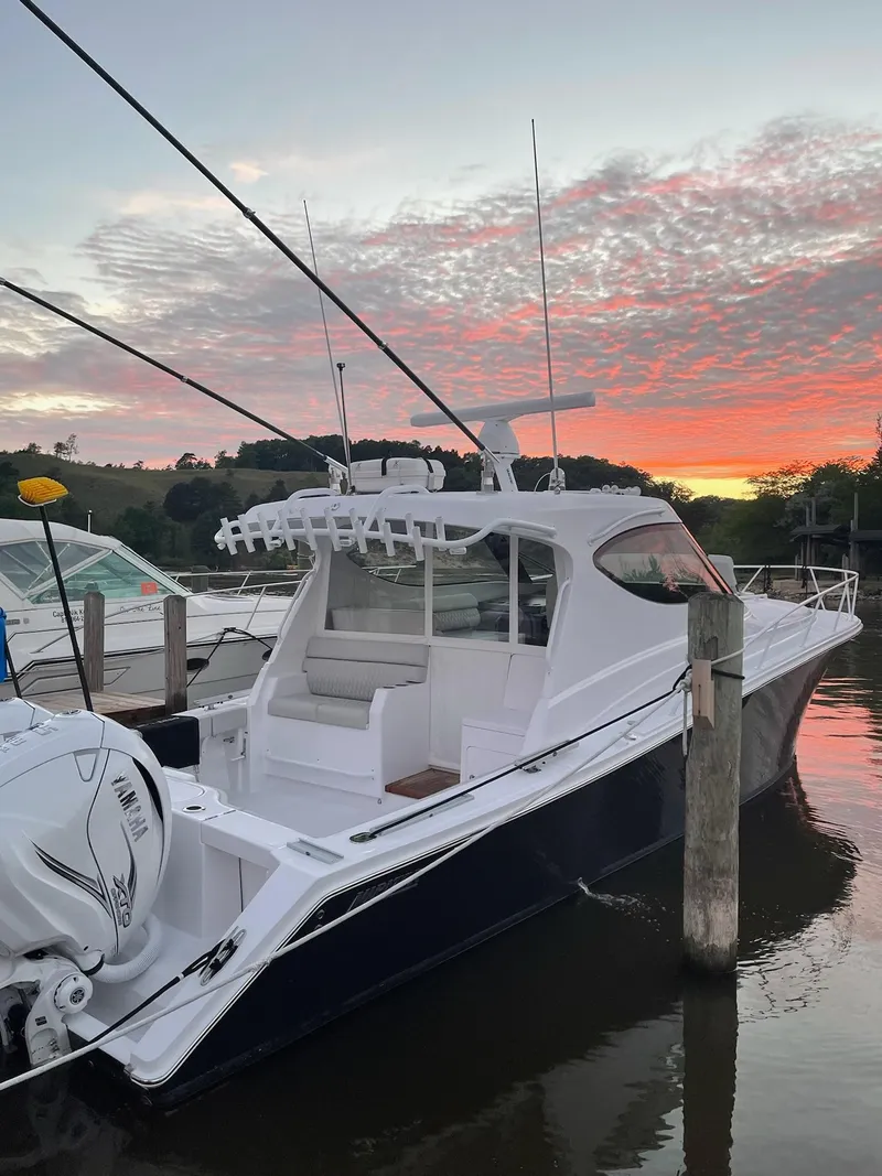 Slide: The Image of 2021 Jupiter 41 SB boat docked at sunset with vibrant sky. - 2