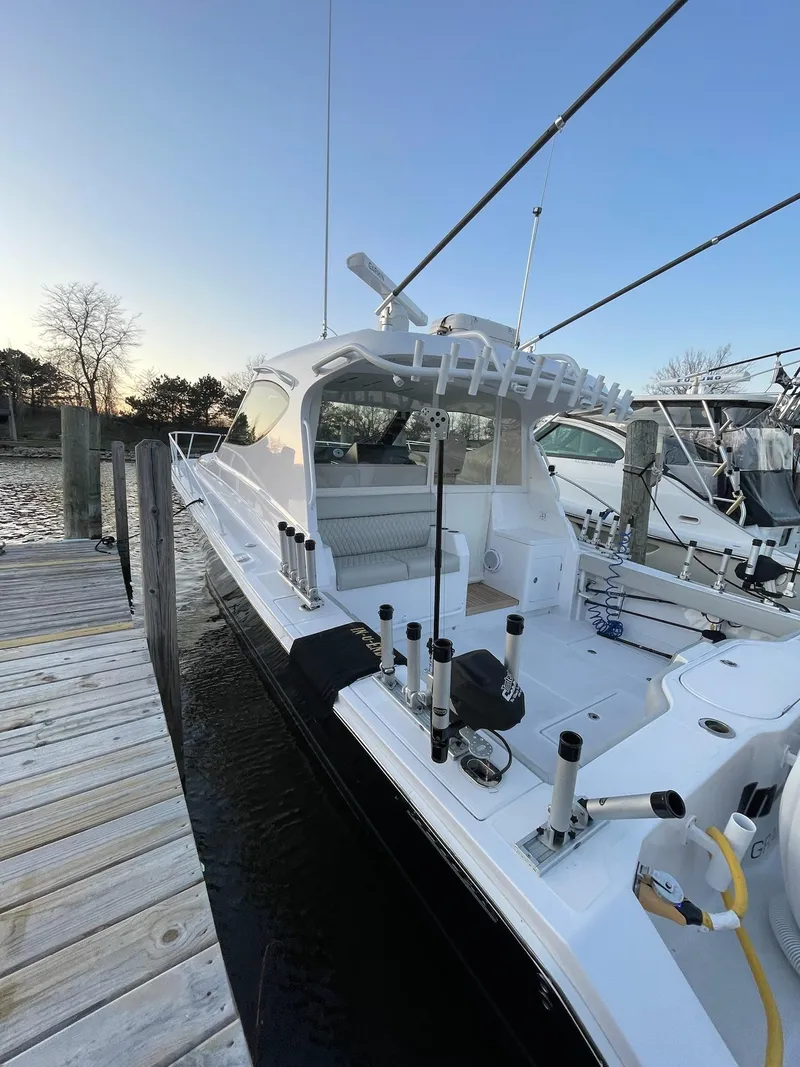 Slide: The Image of 2021 Jupiter 41 SB boat docked at marina, featuring sleek design and fishing equipment. - 20