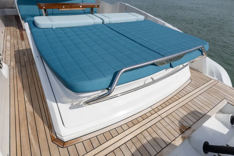 Slide: The Image of The 2025 SACS Rebel 47 features a sleek deck with blue cushions and wooden flooring. - 22