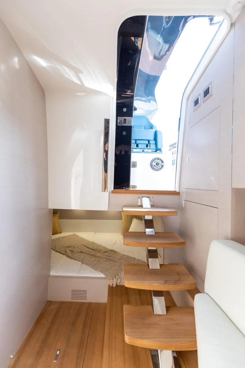Slide: The Image of Interior of the SACS Rebel 47 with wooden steps and a cozy sleeping area. - 42