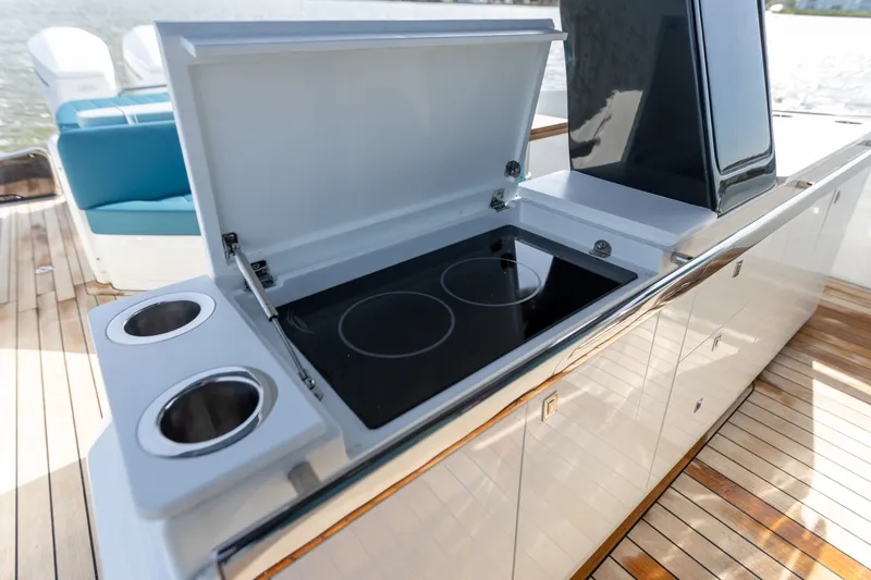 Slide: The Image of The 2025 SACS Rebel 47 features a modern outdoor kitchen with an induction cooktop and cup holders. - 36
