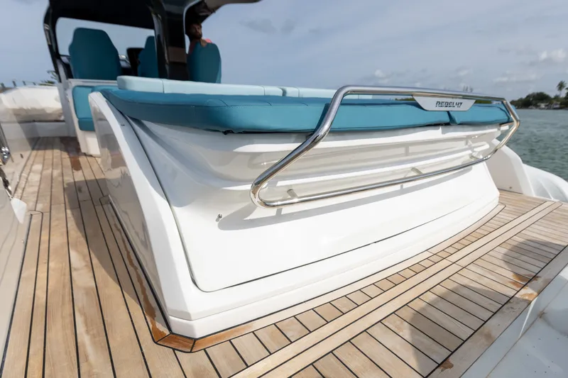 Slide: The Image of The image shows the deck of a 2025 SACS Rebel 47 with blue cushions and wood paneling. - 21