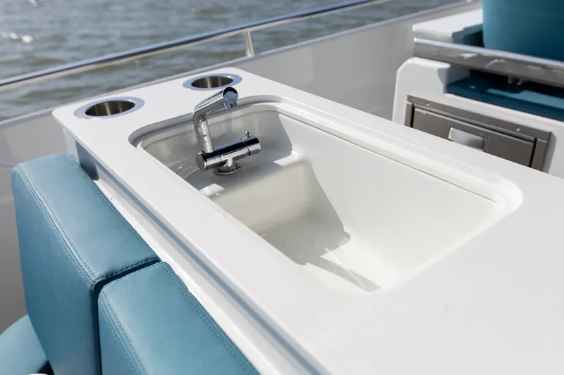 Slide: The Image of The image shows a modern sink on a boat with blue upholstery and stainless steel fixtures. - 37