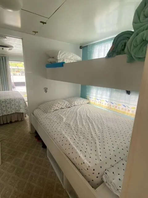 Slide: The Image of Interior of 1985 Arc houseboat with cozy bunk beds and polka dot bedding. - 14