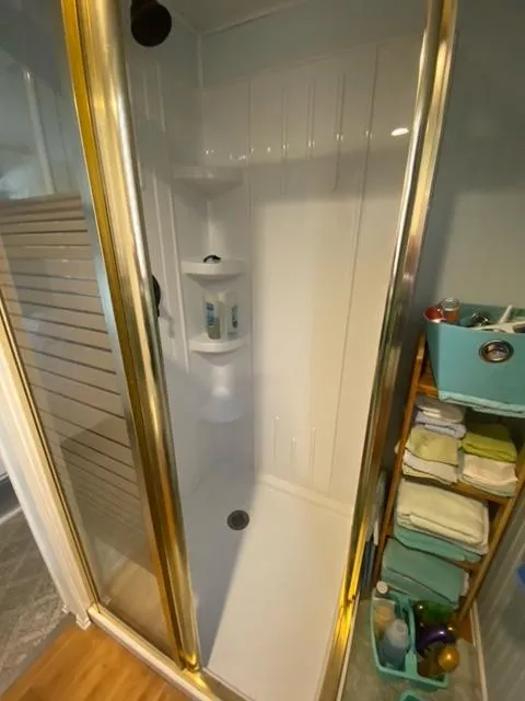 Slide: The Image of Compact shower in 1985 Arc houseboat with gold trim and organized toiletries. - 16