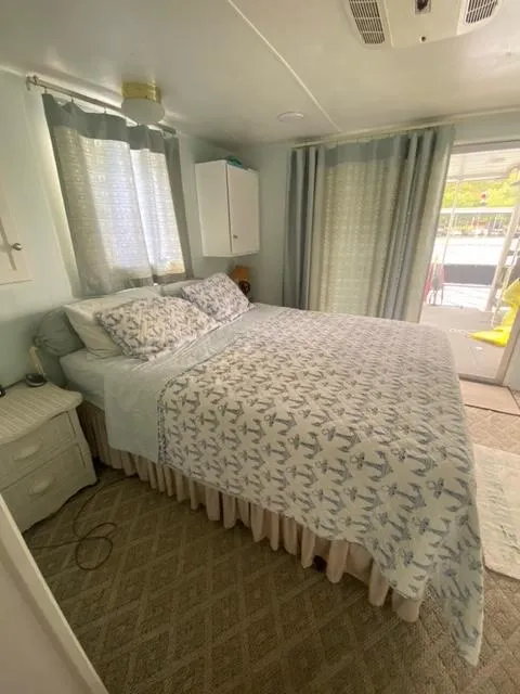 Slide: The Image of Cozy bedroom in 1985 Arc houseboat with patterned bedding and natural light. - 18
