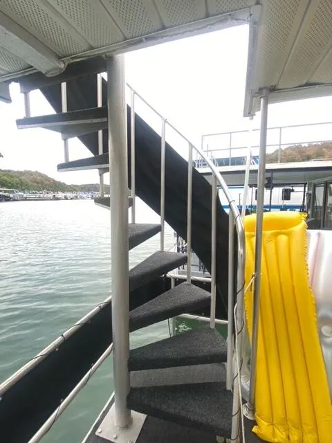 Slide: The Image of Spiral staircase on 1985 Arc houseboat with yellow floatation device. - 19