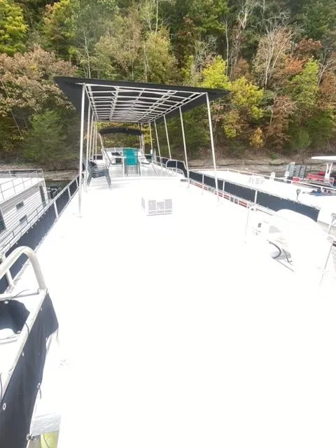 Slide: The Image of 1985 Arc houseboat with spacious deck, surrounded by lush trees. - 22