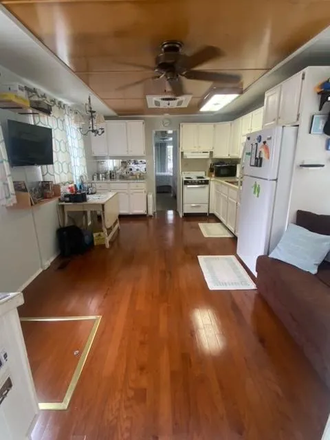 Slide: The Image of Spacious 1985 Arc houseboat interior with wooden flooring and modern kitchen amenities. - 5