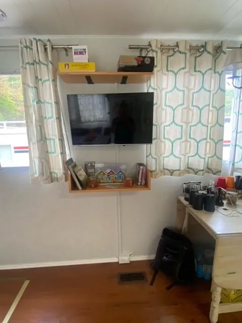 Slide: The Image of Interior of 1985 Arc houseboat with TV, shelves, and desk setup. - 9