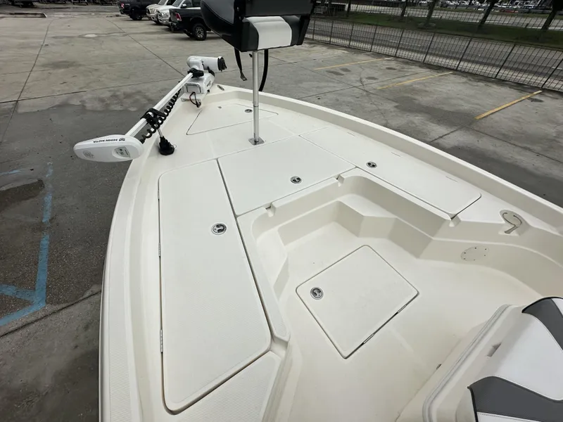 Slide: The Image of 2023 Skeeter SX230 boat deck with storage compartments and trolling motor. - 16