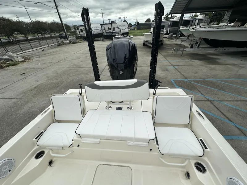 Slide: The Image of 2023 Skeeter SX230 boat interior with seating and motor, parked in a lot. - 21