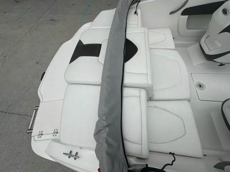 Slide: The Image of 2012 Chaparral 18 H2O Sport boat interior with white seating and gray cover. - 10